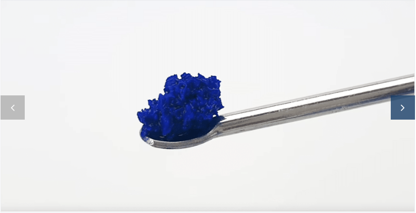 Close-up of blue granules on a metal instrument.
